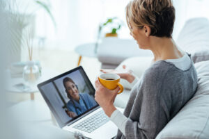 Terapia online funciona? Mulher conversando com profissional através de uma chamada de áudio e vídeo no computador.