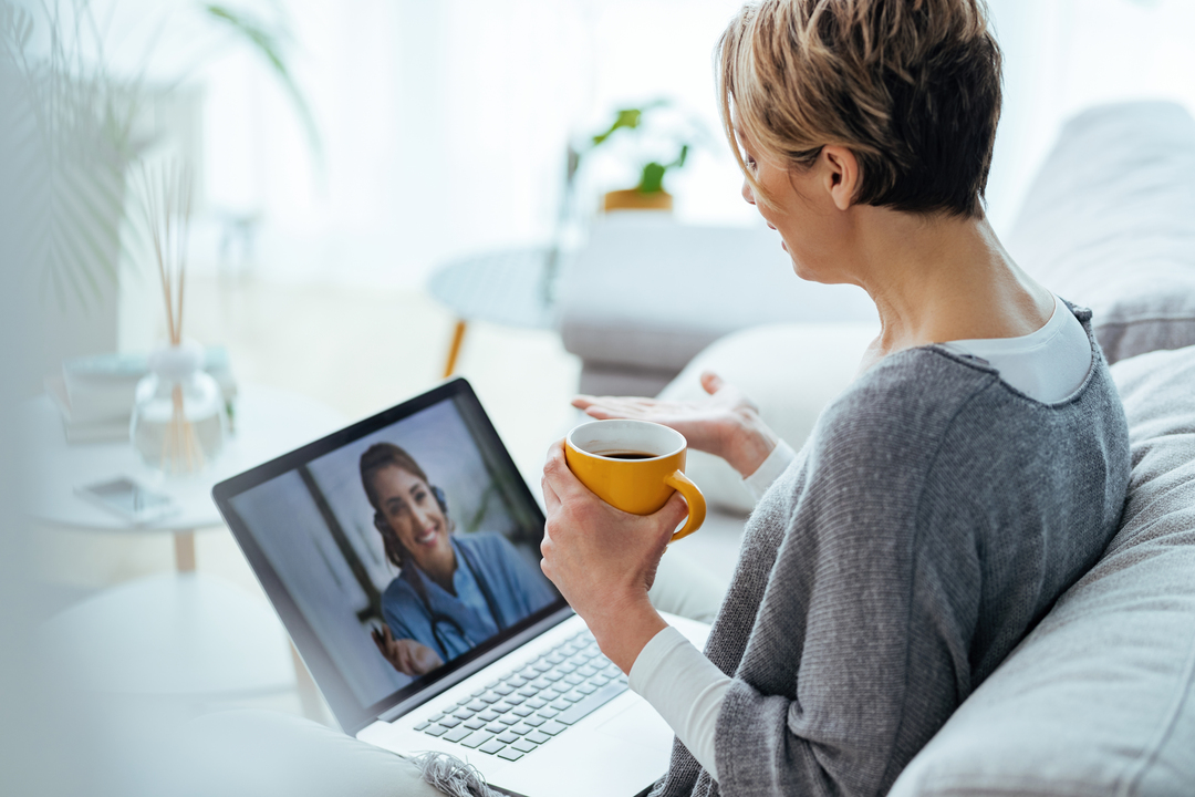 Mulher conversando com profissional através de uma chamada de áudio e vídeo no computador.
