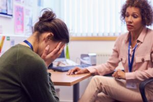 Veja a importância da saúde mental no trabalho com a salz! Profissional acolhe trabalhadora abalada no escritório sobre saúde mental no trabalho.
