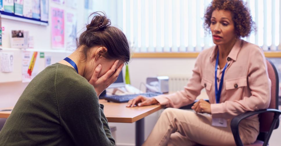 Profissional acolhe trabalhadora abalada no escritório sobre saúde mental no trabalho.
